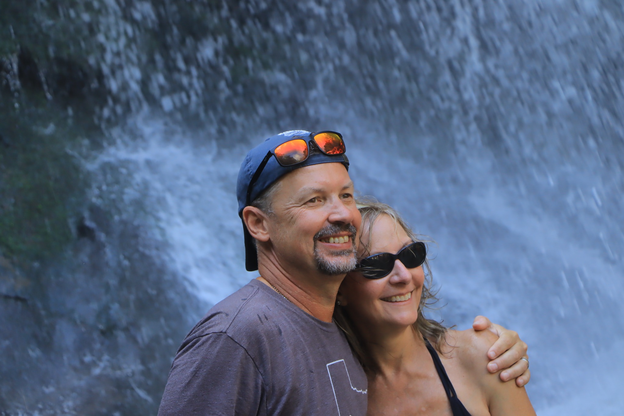 A couple together in front of a waterfall