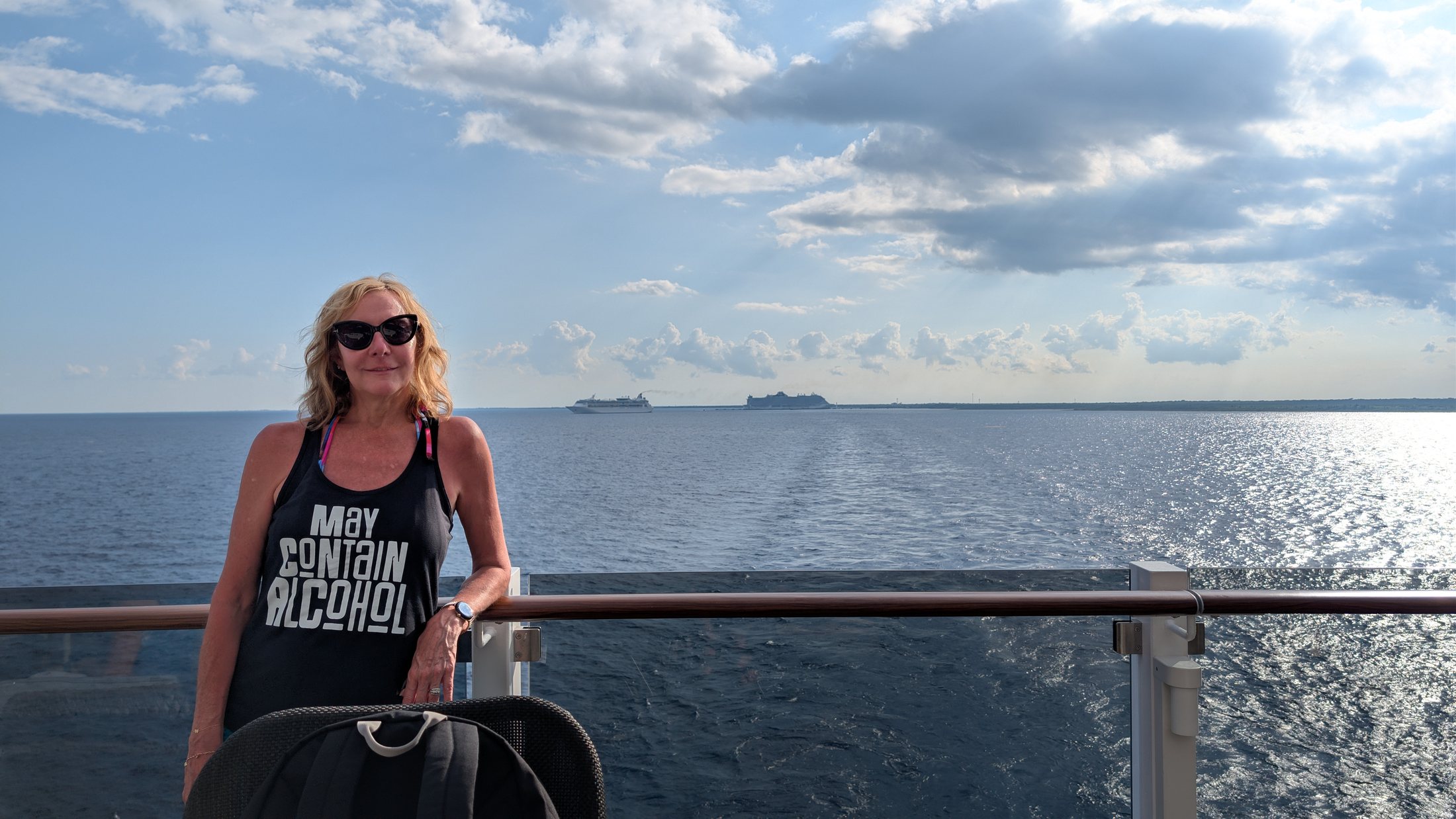 Rebecca standing on a ship deck with the Caribbean behind her
